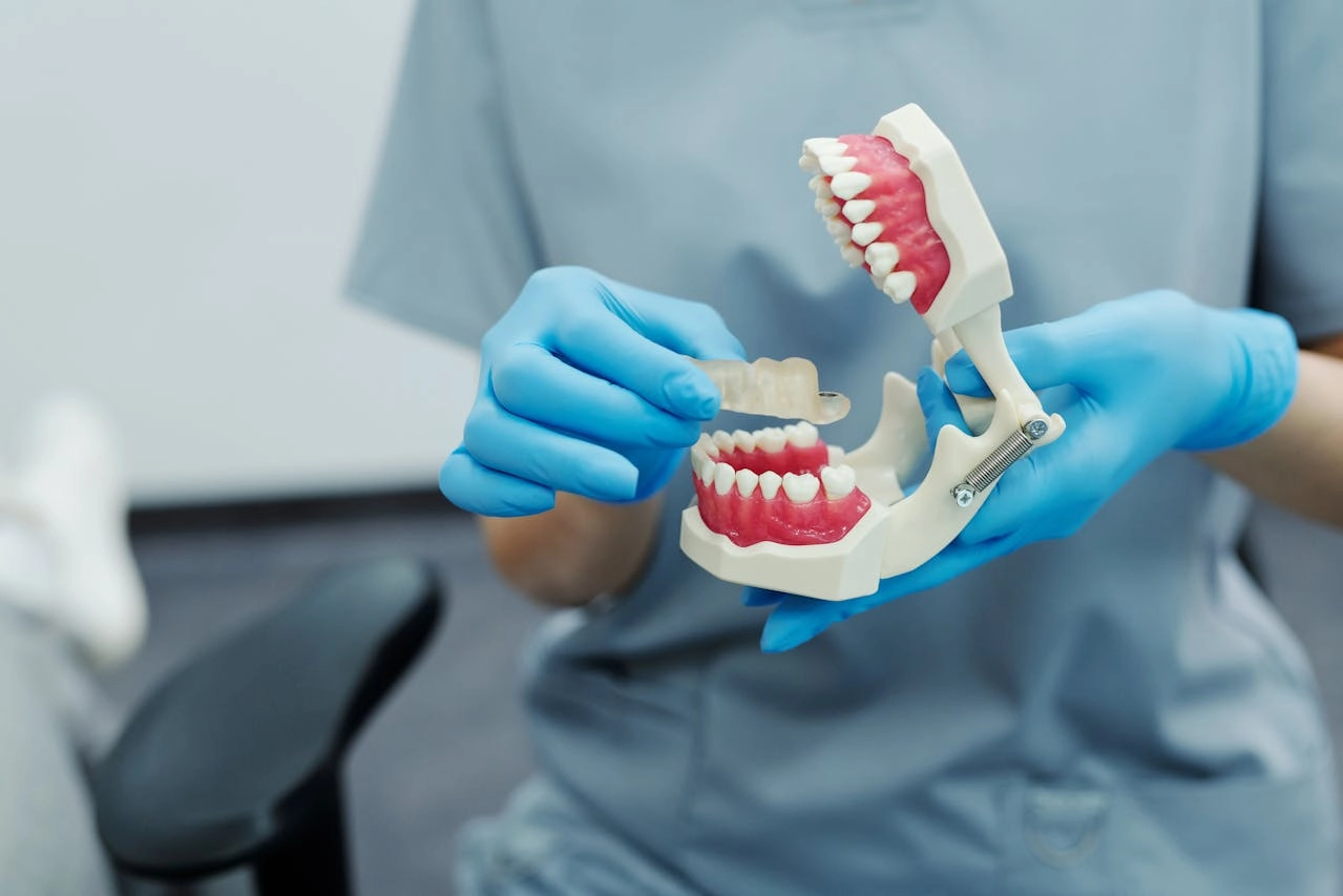Doctora explicando la microabrasión dental con una prótesis