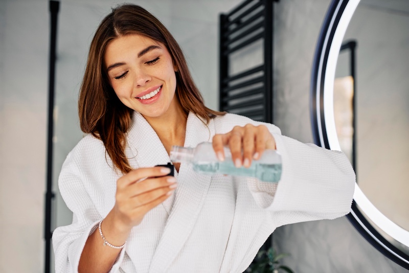 Mujer usando enjuague bucal