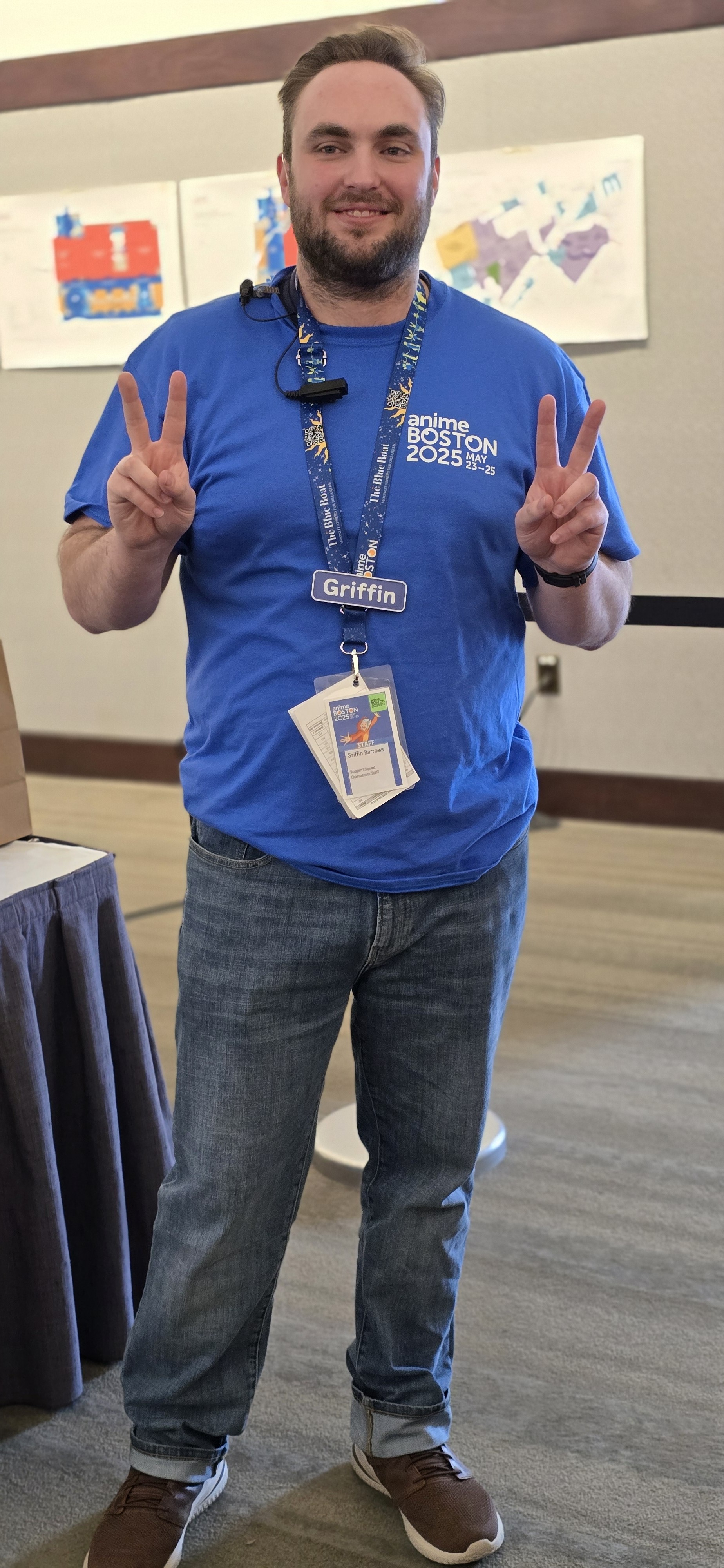 Me dressed to staff Anime Boston holding up dual peace signs while smiling