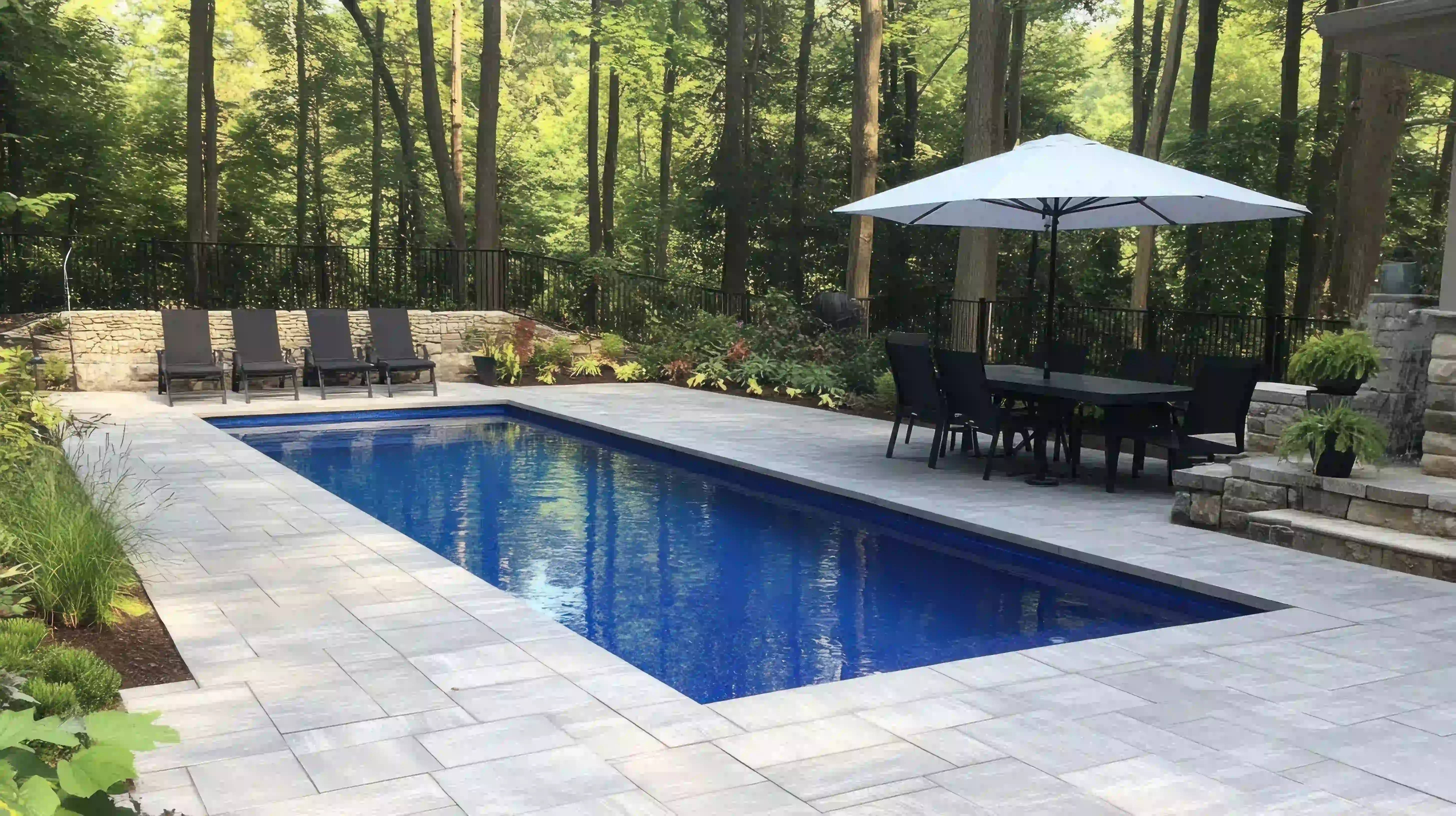 Inground pool with a stone patio and dining area