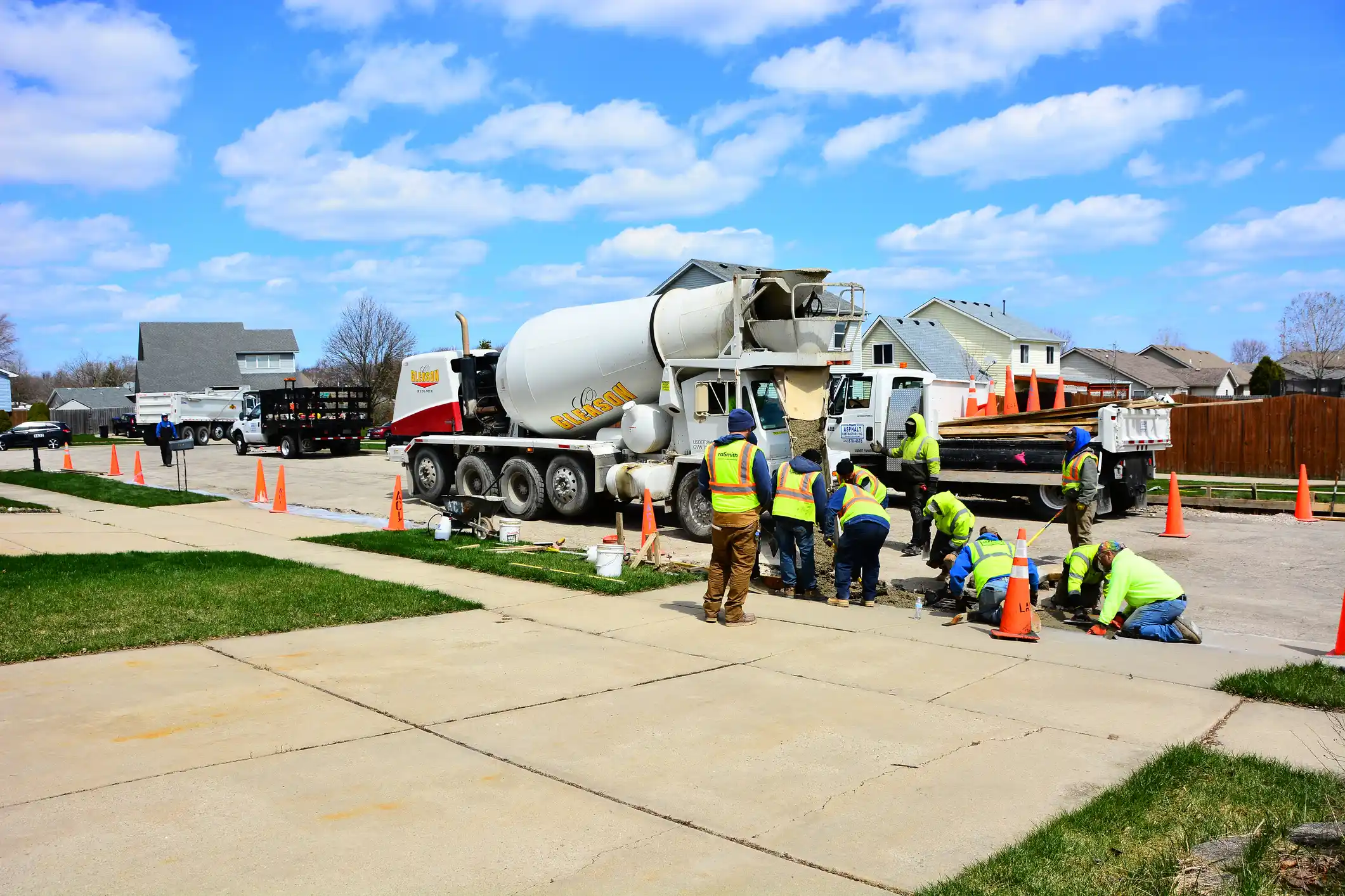 Concrete crew pouring a driveway beside a mixer truck