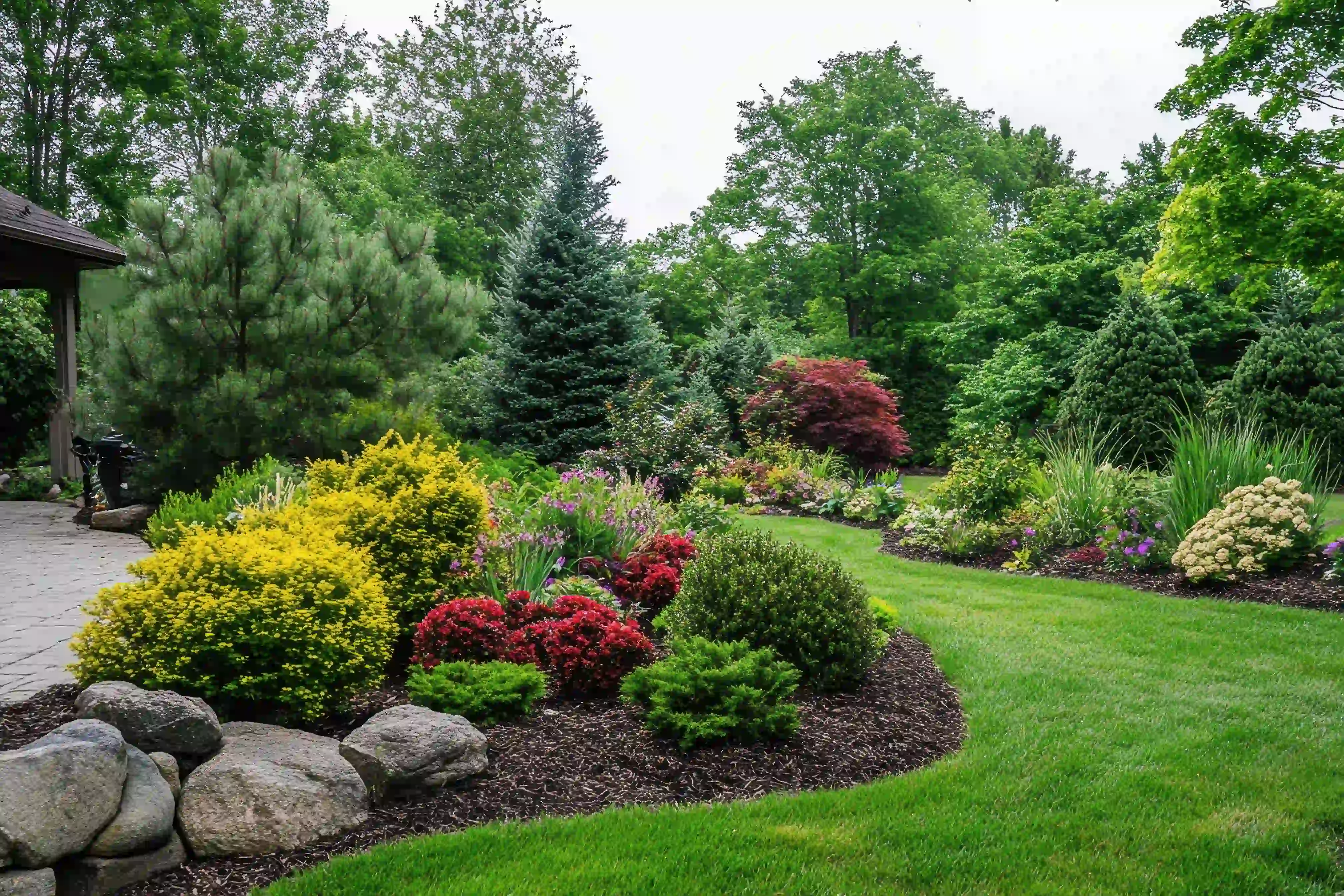 Landscaped yard with shrubs, boulders and fresh mulch