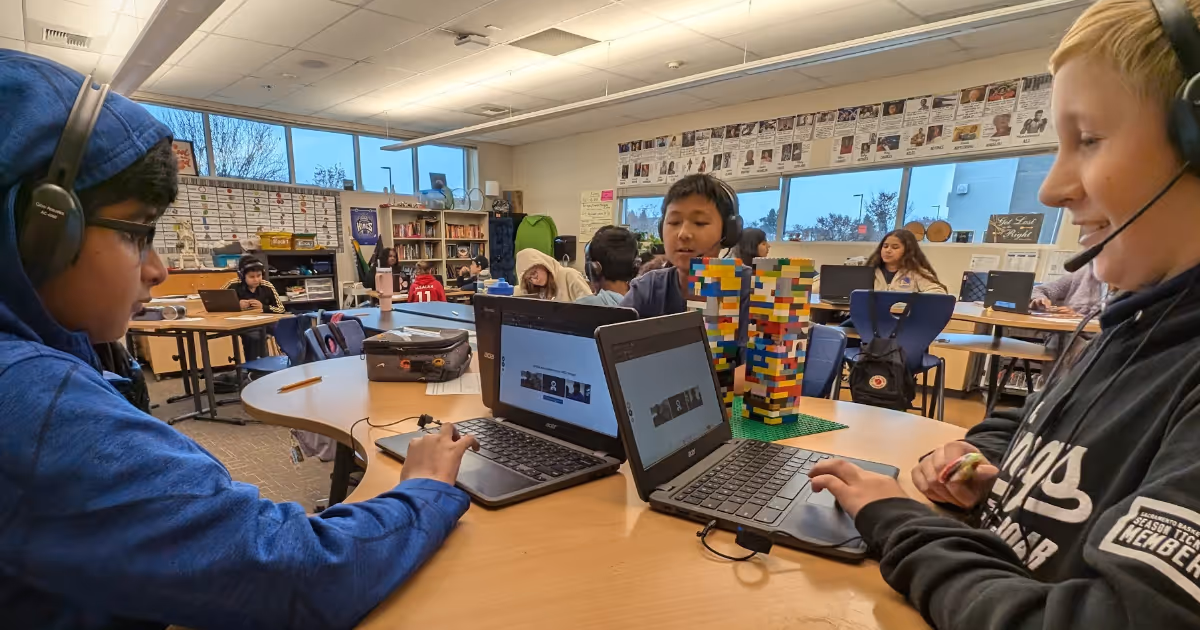 Students wearing headsets work together on laptops during a small-group math session at Westlake Charter School