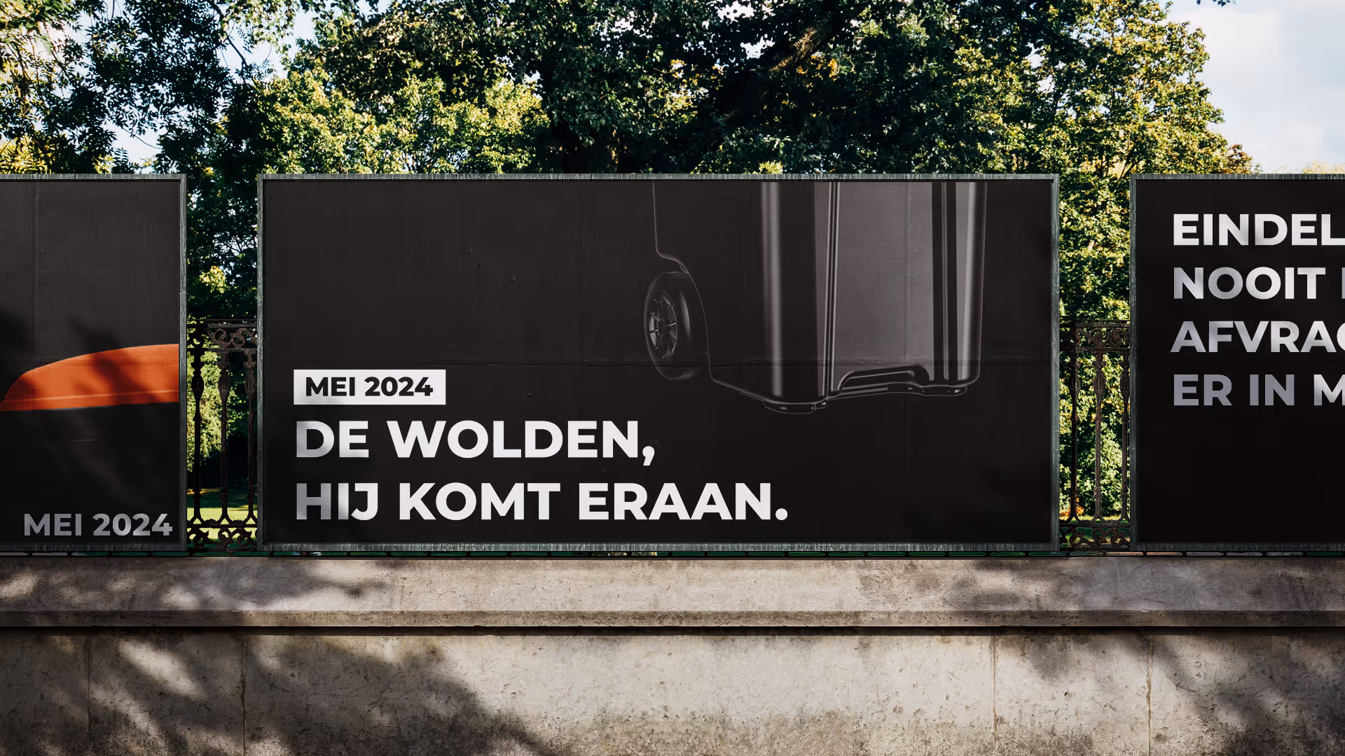 Billboard met de tekst 'Mei 2024 De Wolden, hij komt eraan' en een afbeelding van een zwarte afvalcontainer met wielen.