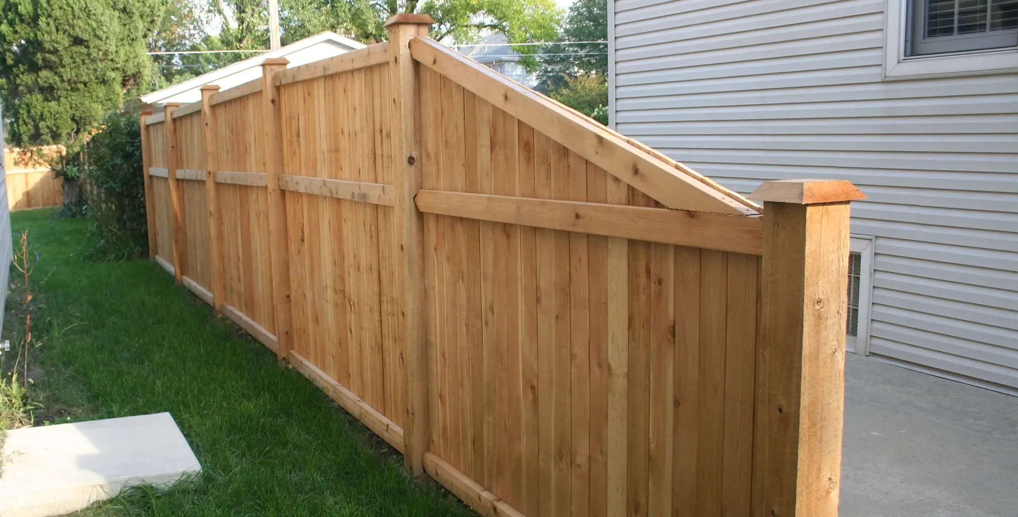 second photo of a wooden fence, and behind it a house