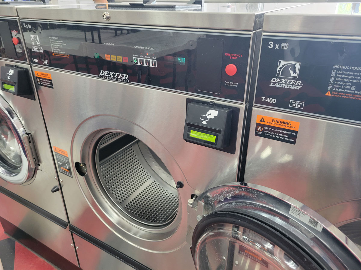 Dexter commercial front-load washing machine with its door open at the laundromat