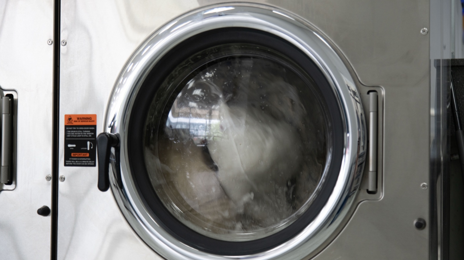 Commercial washer mid-cycle with a load of laundry