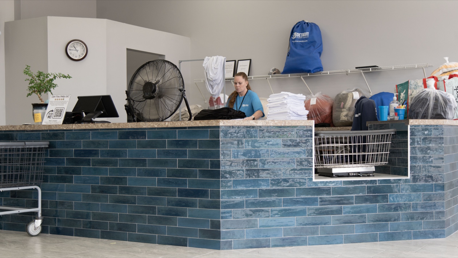 Front counter with a Detroit Laundry Service bag and finished orders