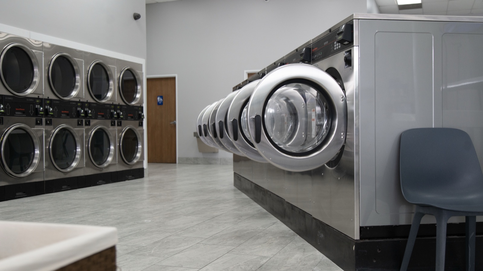 Clean, well-lit laundry facility with rows of machines