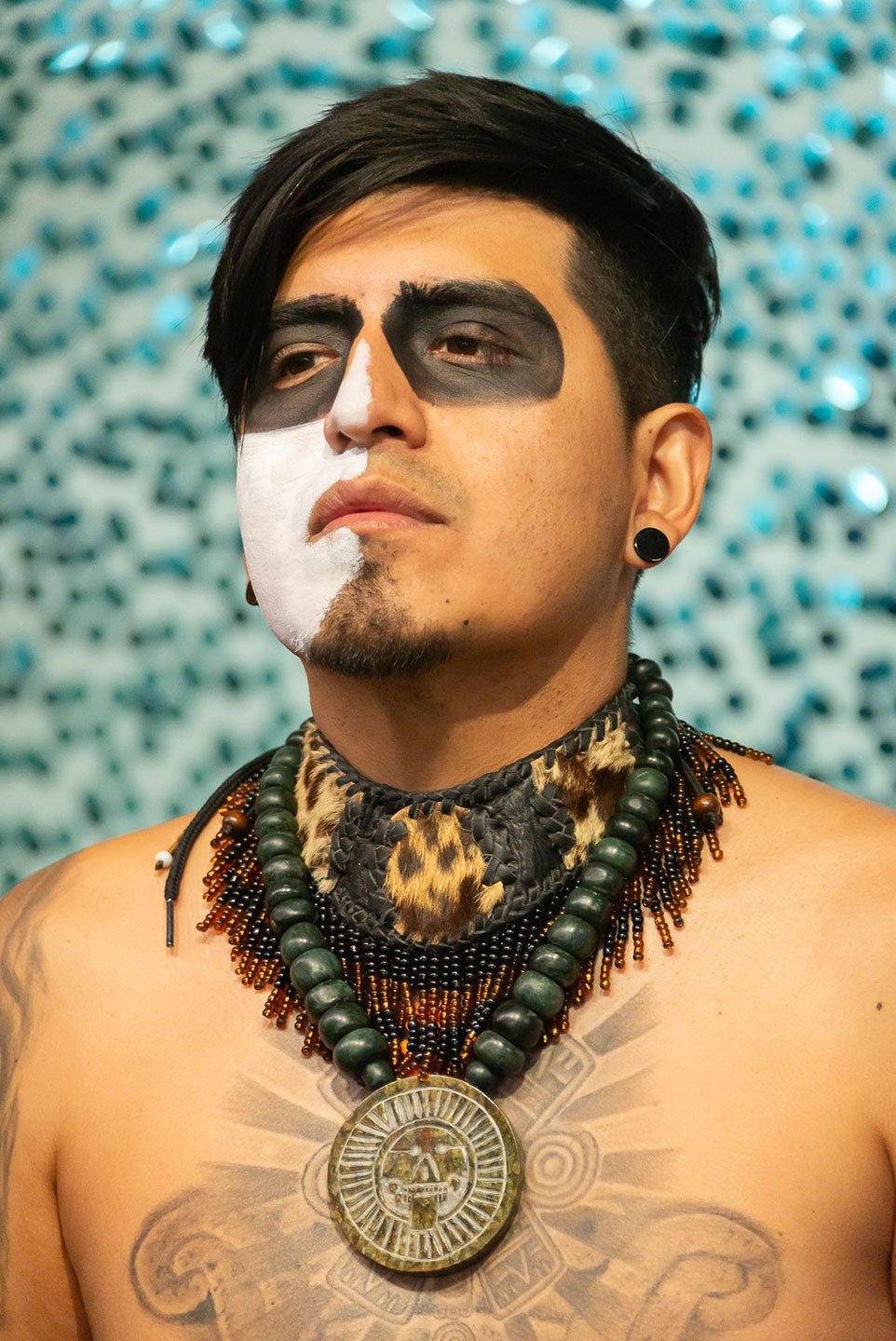 Photography of young man wearing black and whit make up and ornate jewelry