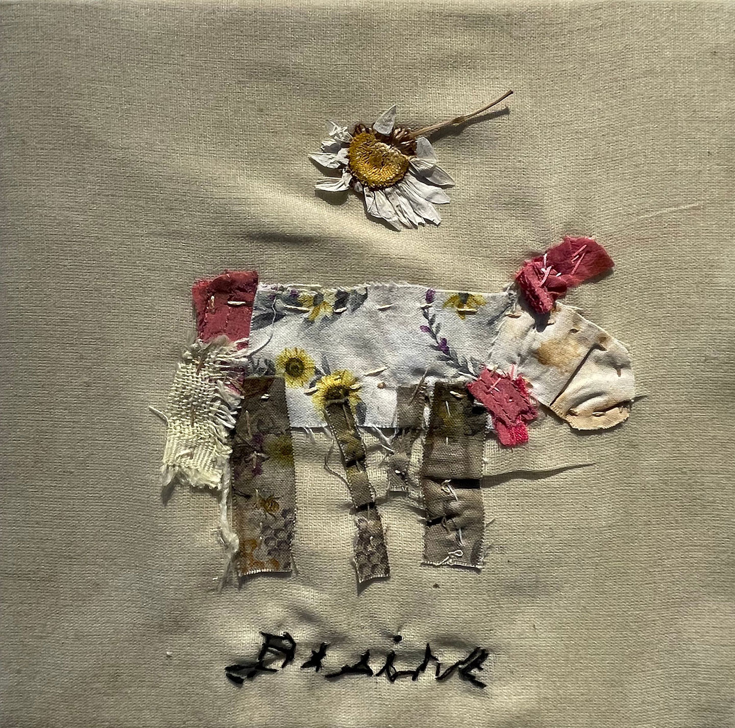 Embroidered image of cow with daisy