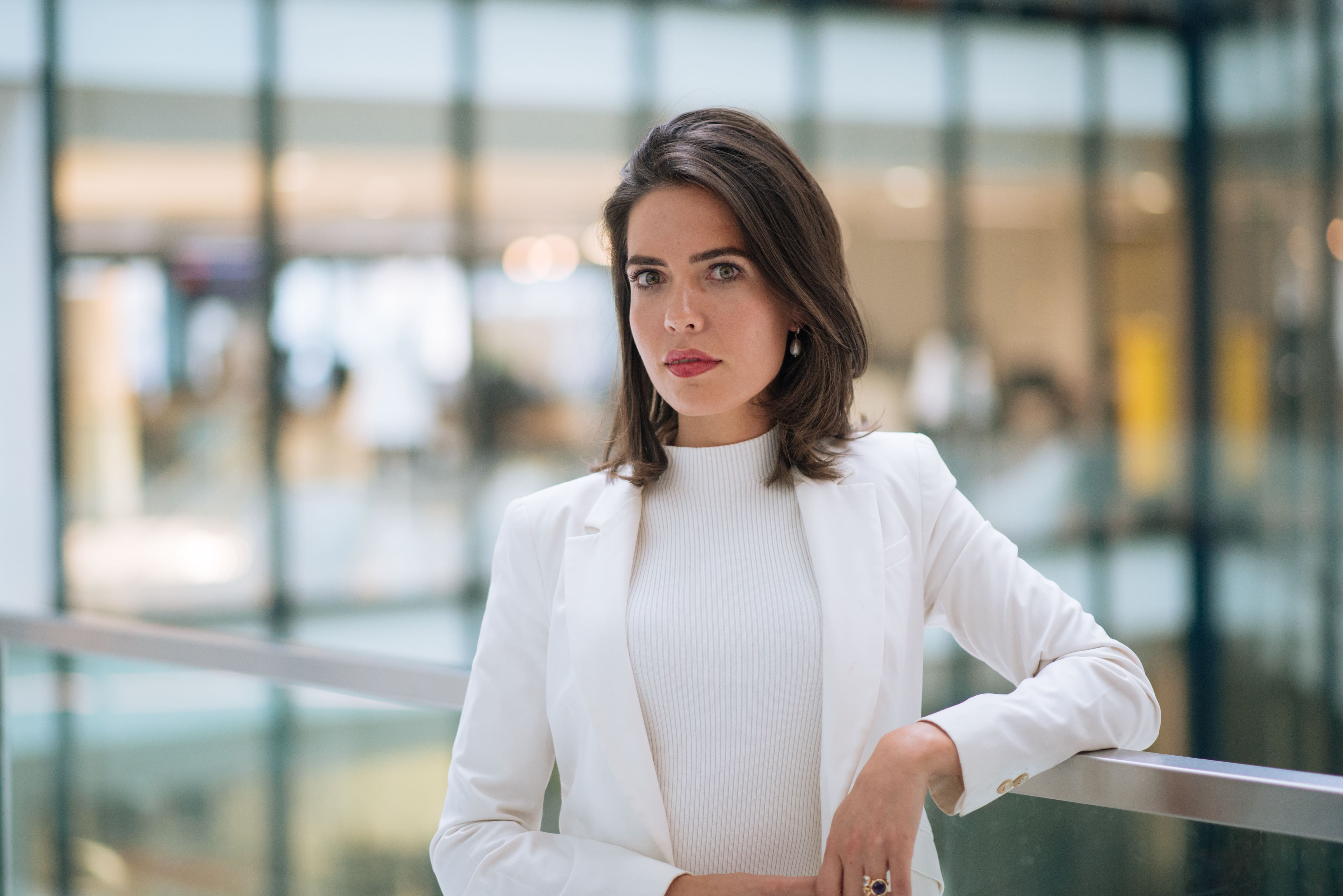 A woman in a white jacket and white shirt.