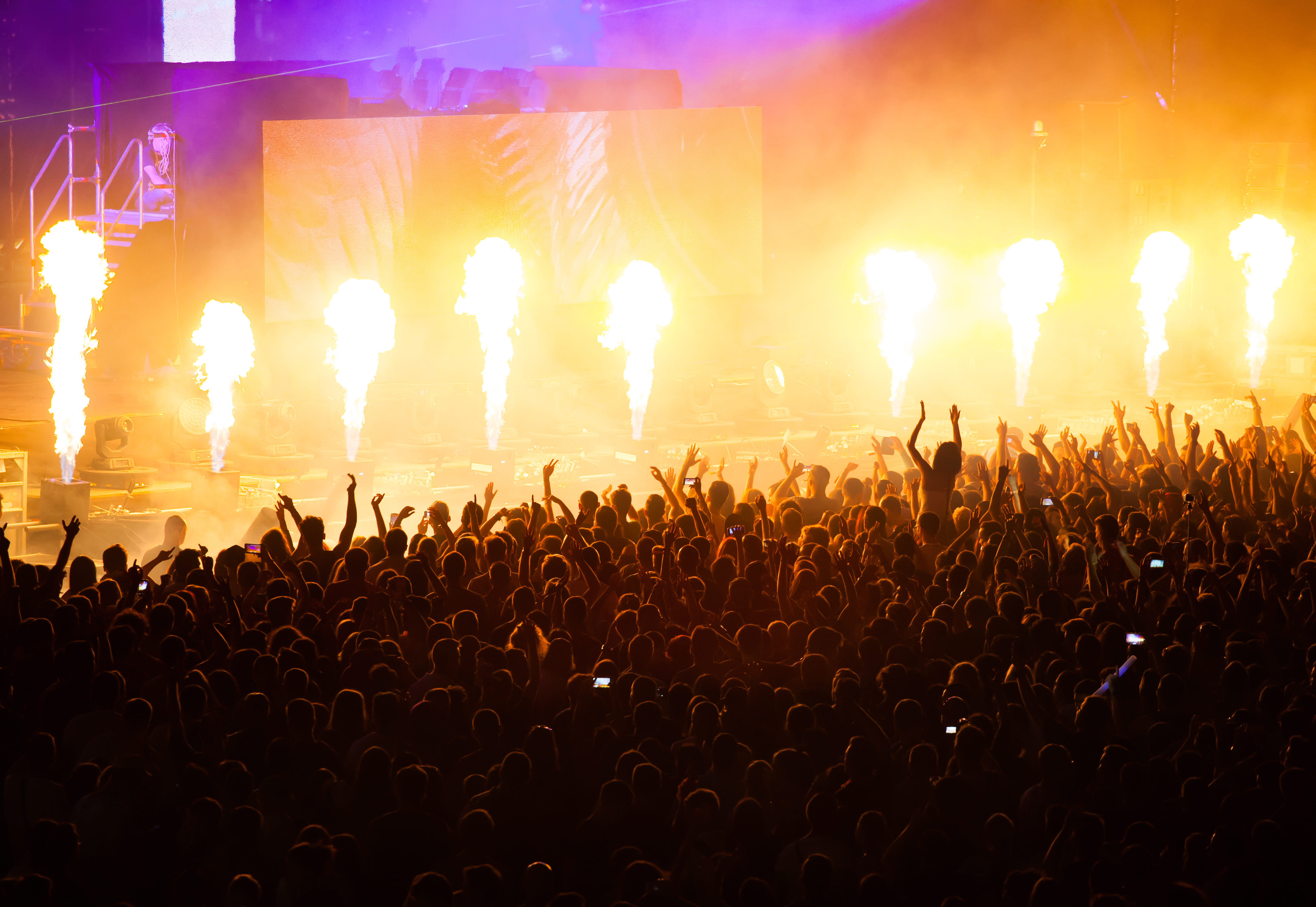 A crowd of people are watching a show with fireworks.