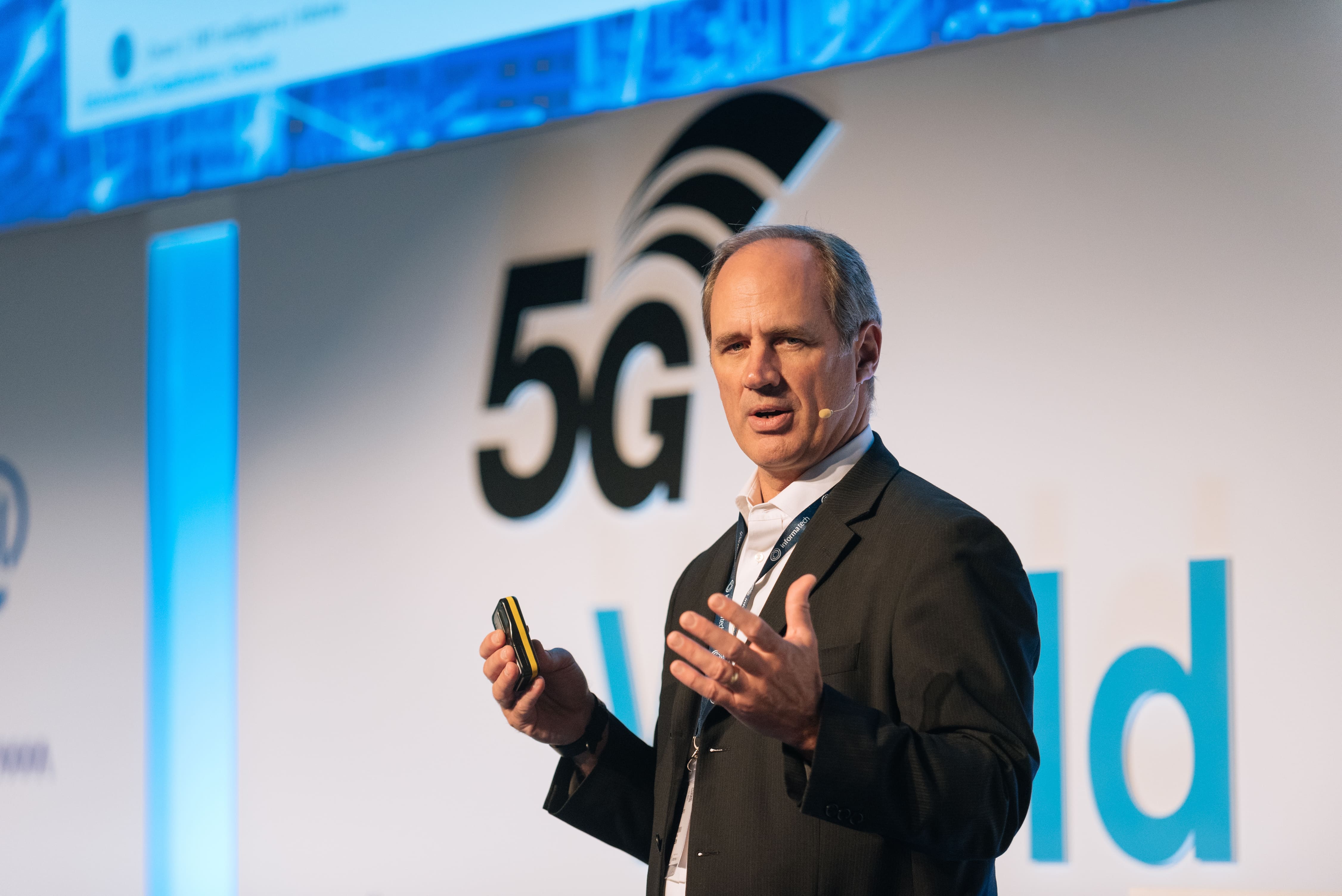 Speaker presenting on stage at the 5G World event, discussing advancements in technology and connectivity