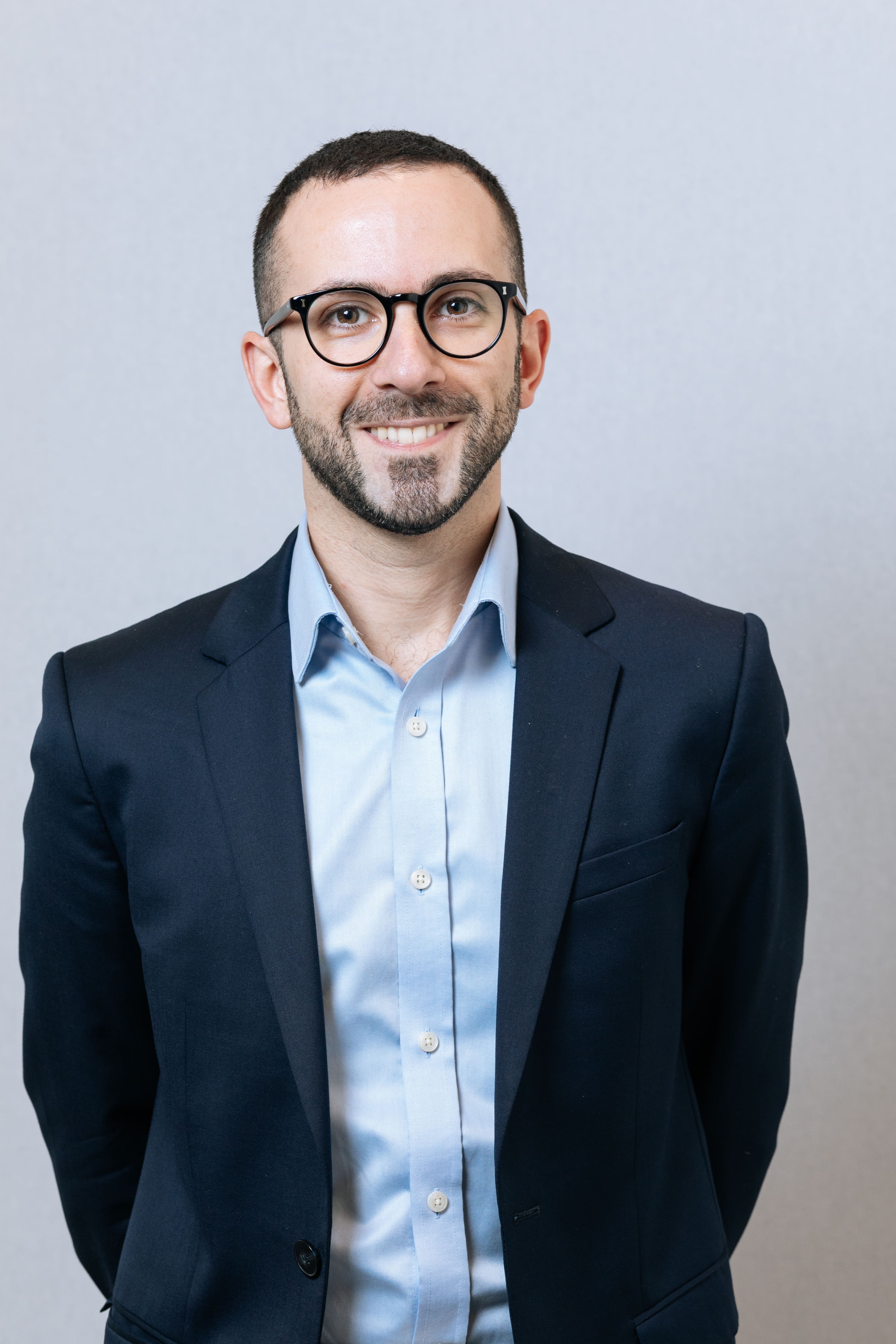 Professional male headshot in business attire with neutral background