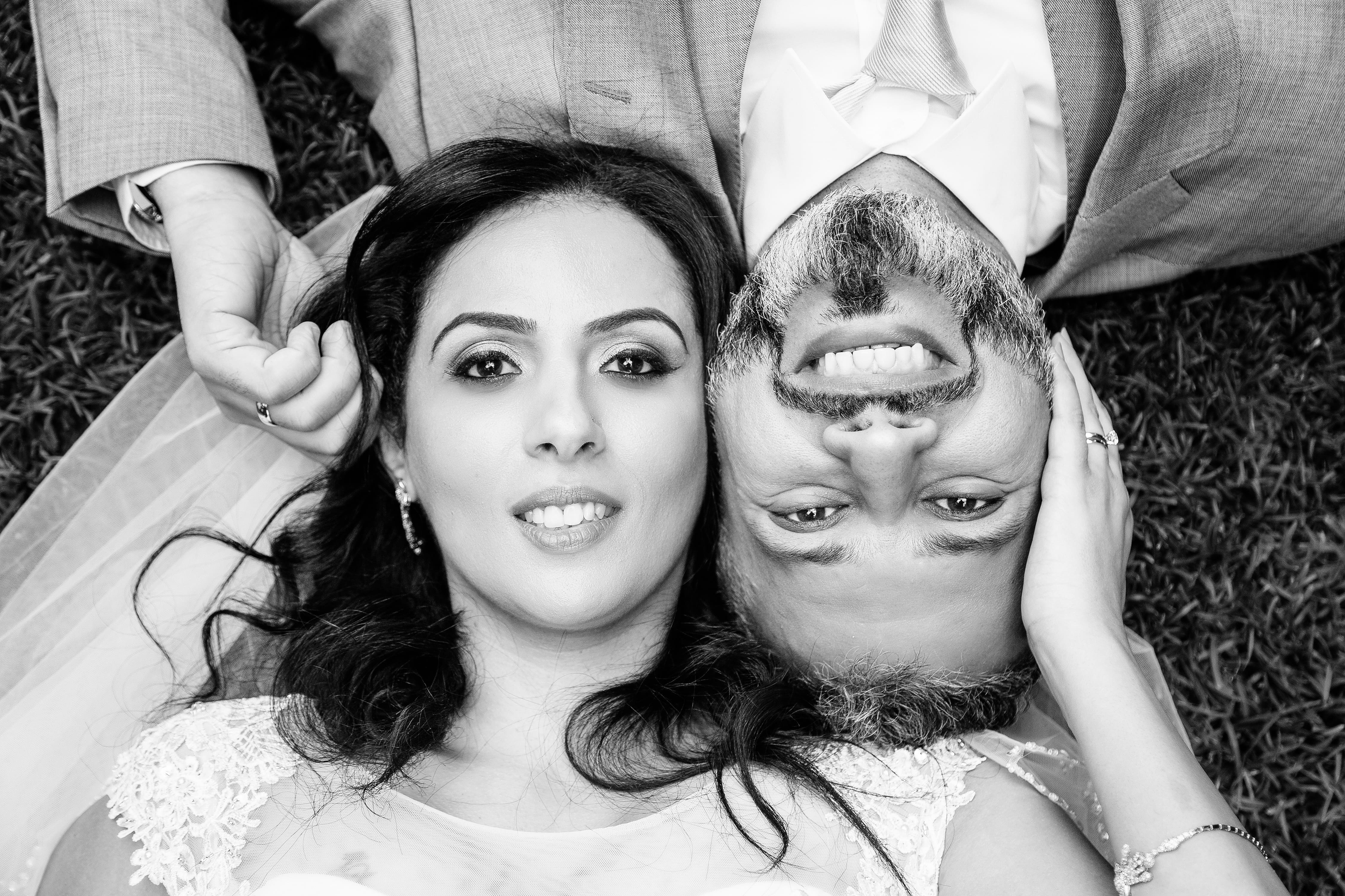 A man and woman are laying down and smiling at the camera.