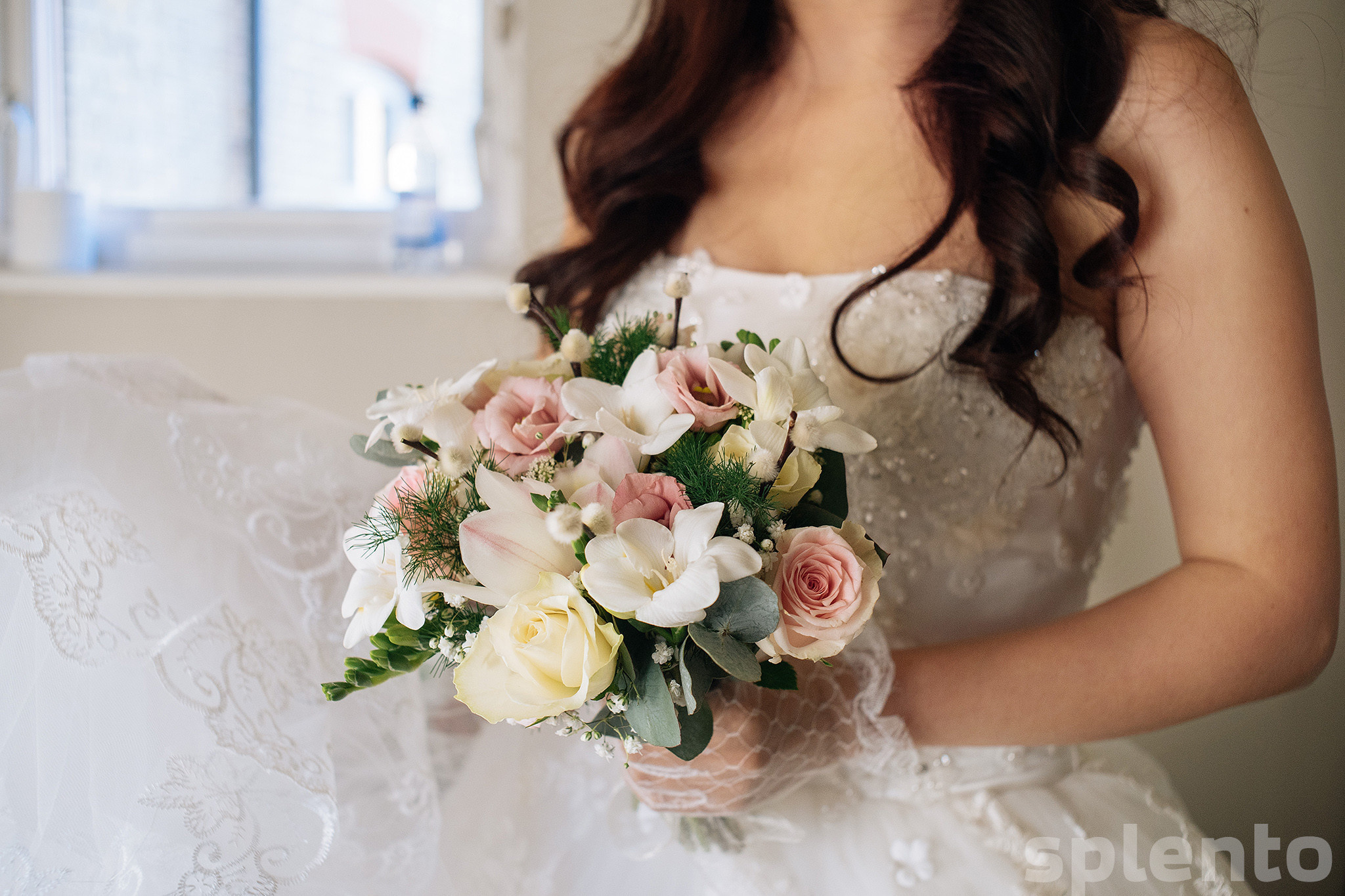 A woman wearing a white dress holding a bouquet of flowers.