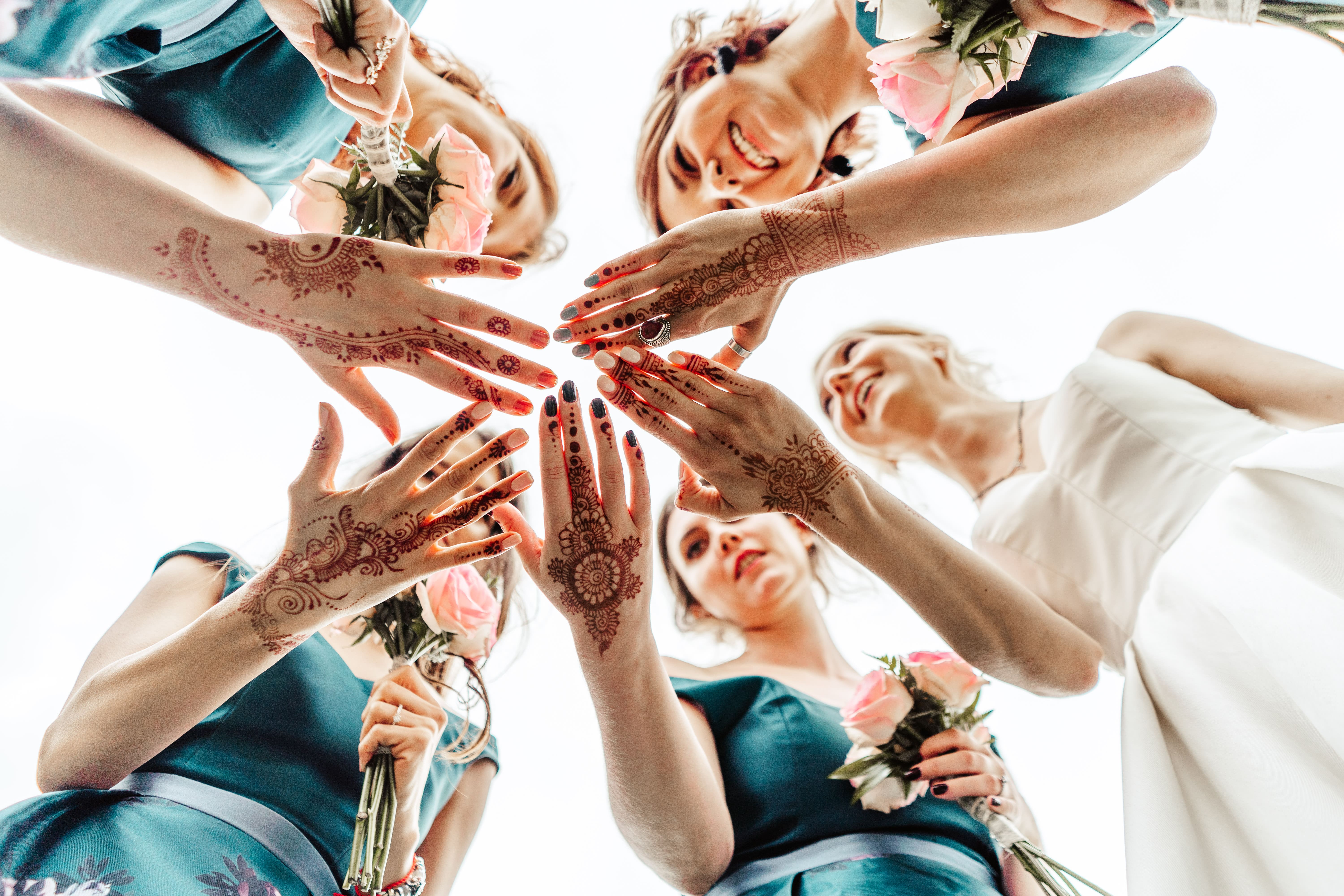 A group of women with tattoos and flowers in their hair.
