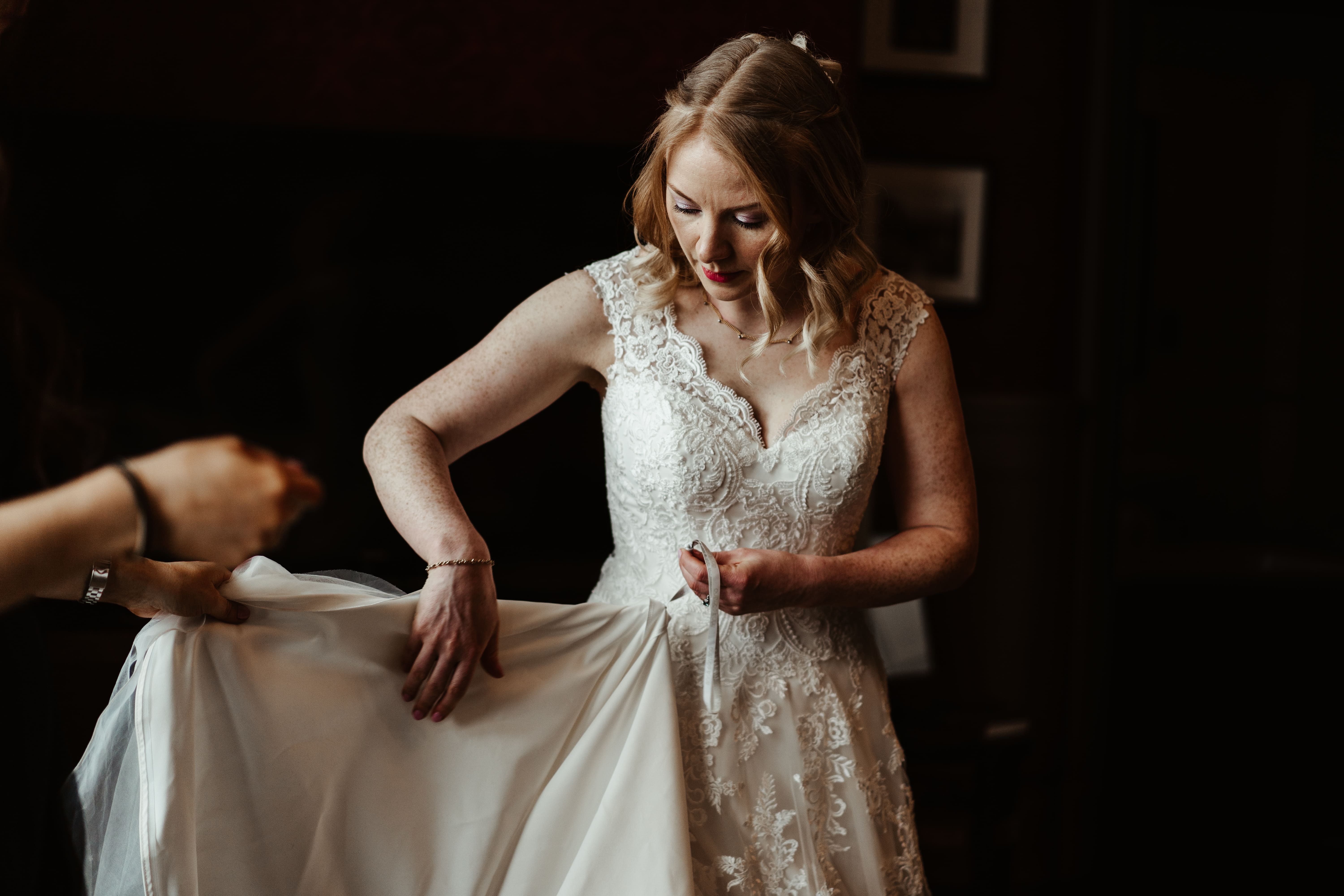 Bride getting ready before the ceremony, adjusting earrings in soft natural light