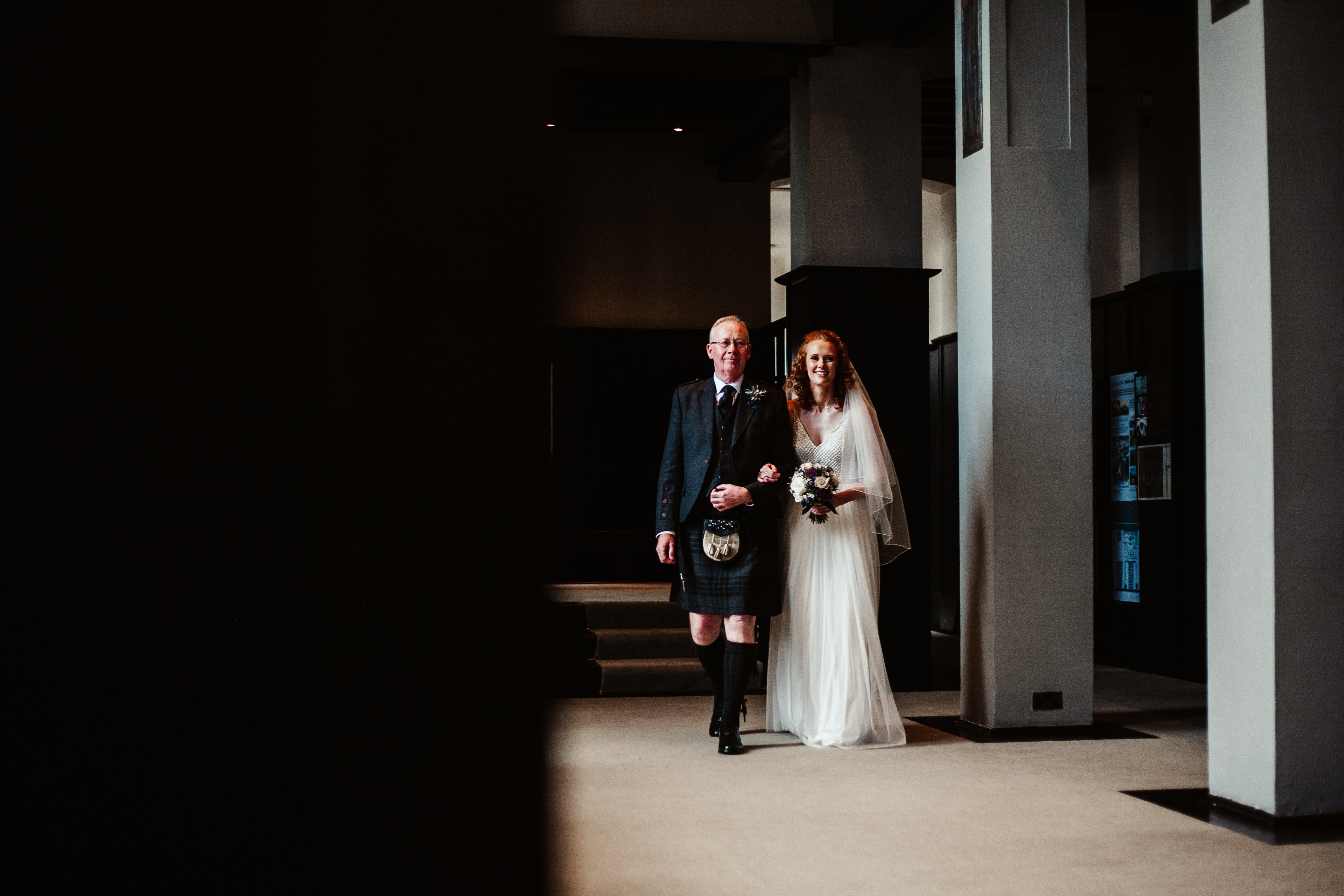 A bride and groom walking down a hallway.