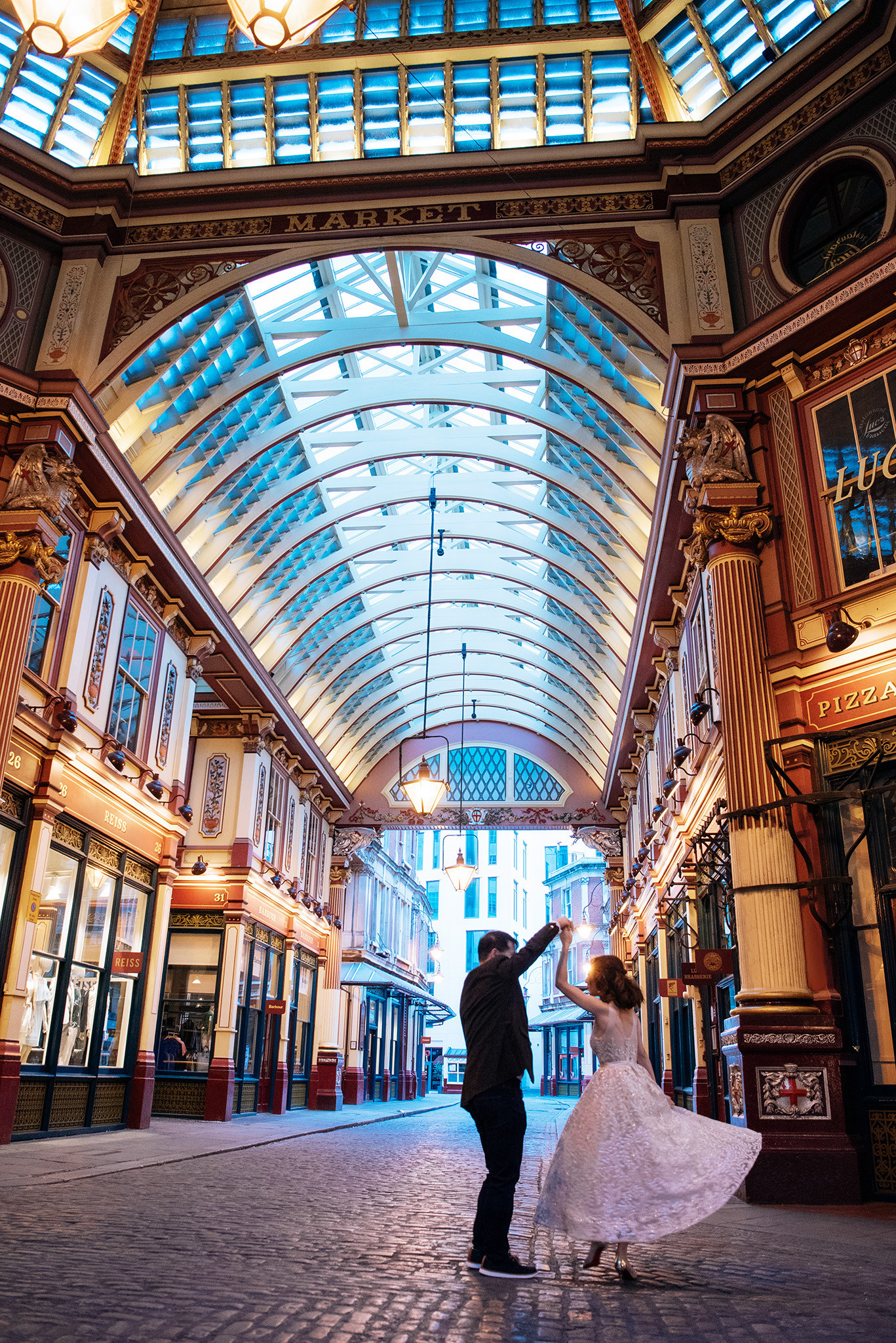 A man and woman dancing in a building with a large arched ceiling.