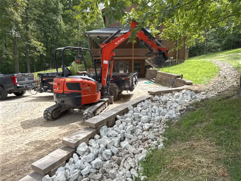 Crosscut lawn and landscape crew uses an excavator to build a drainage solution.
