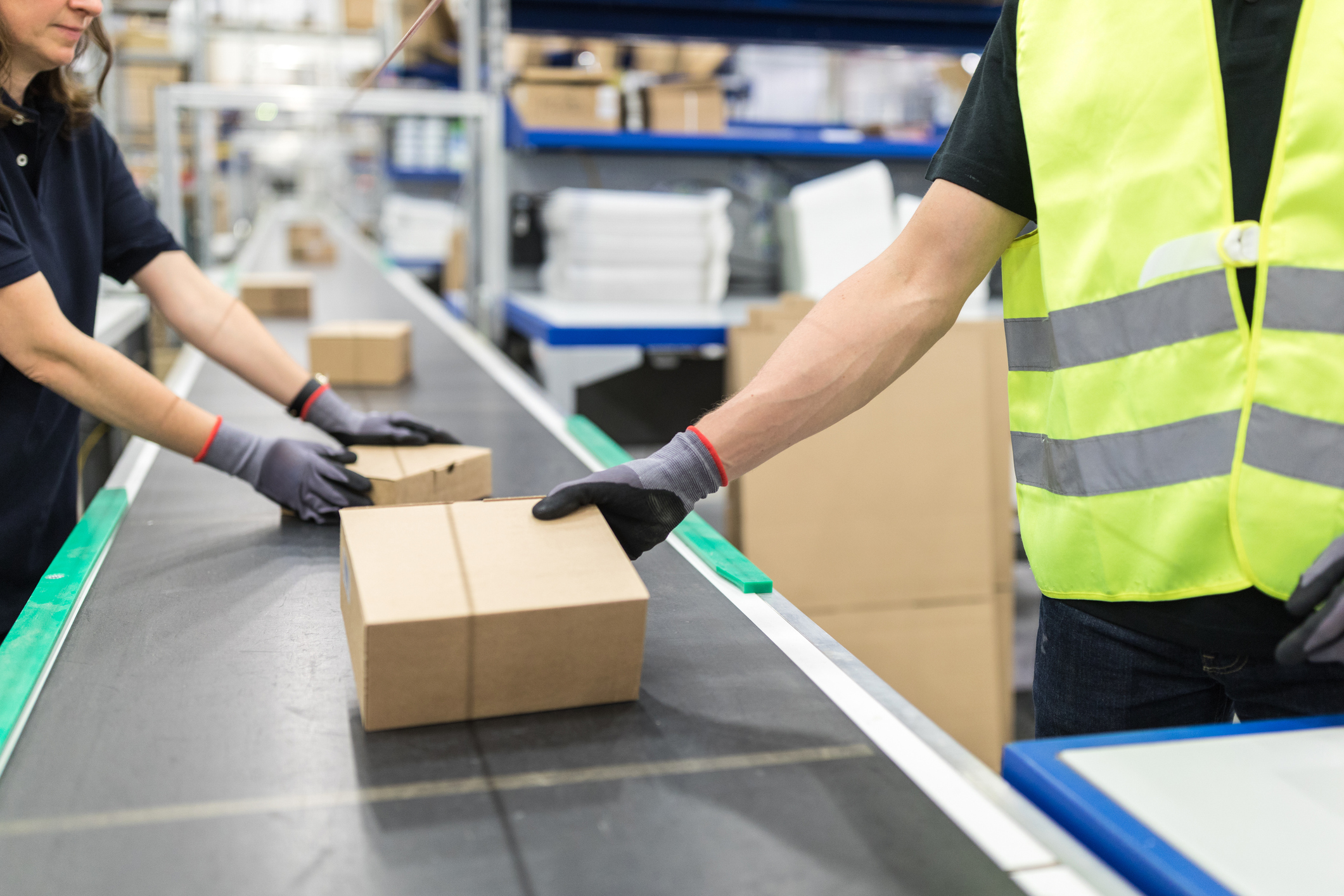 warehouse workers working with packages on a conveyor line