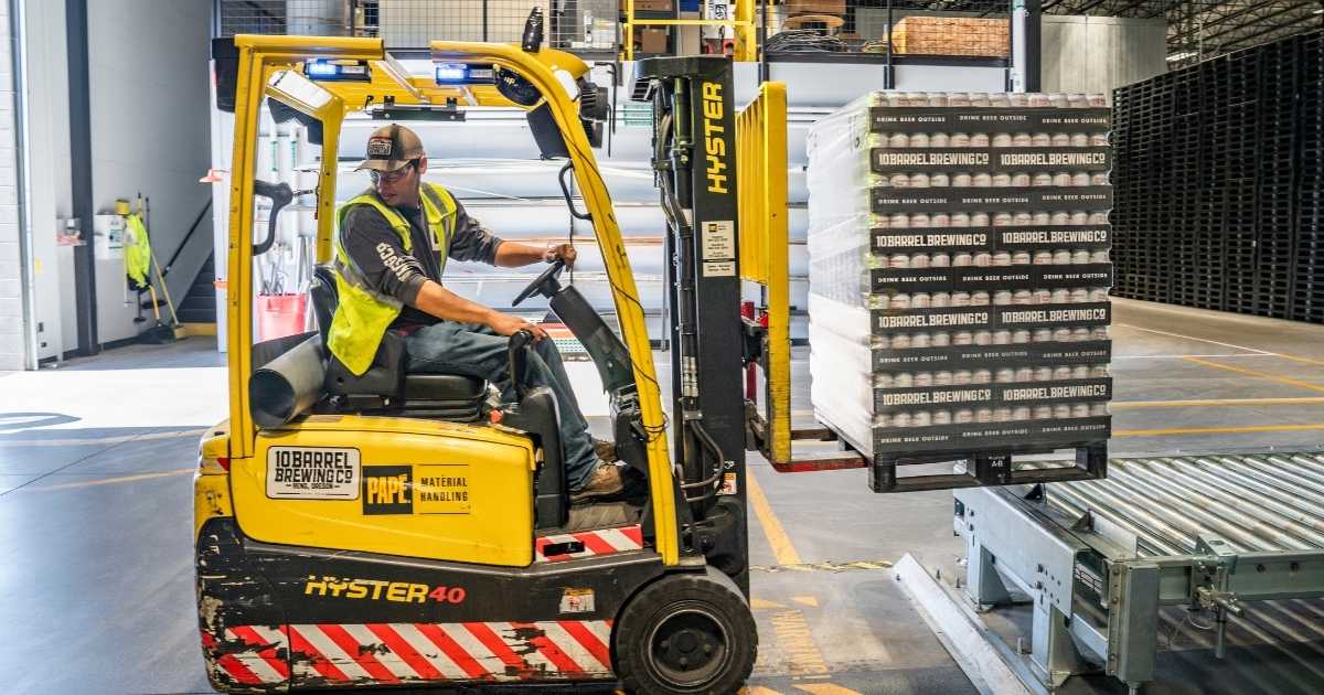 a forklift driver moving a pallet of goods for shipping
