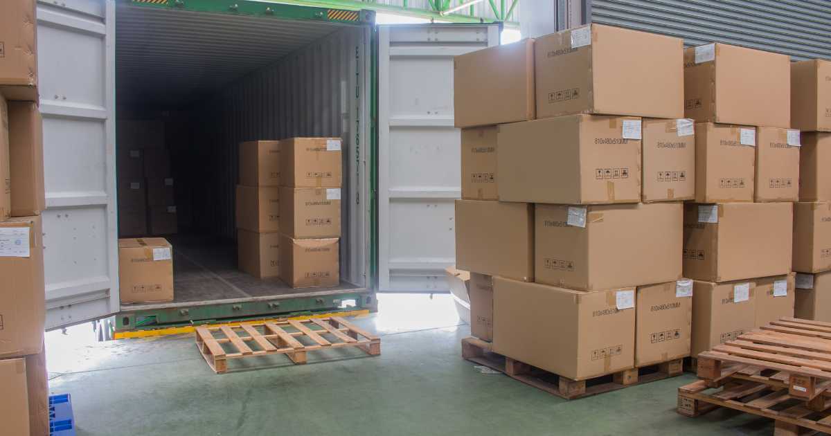 a truck partially unloaded with pallets on the dock