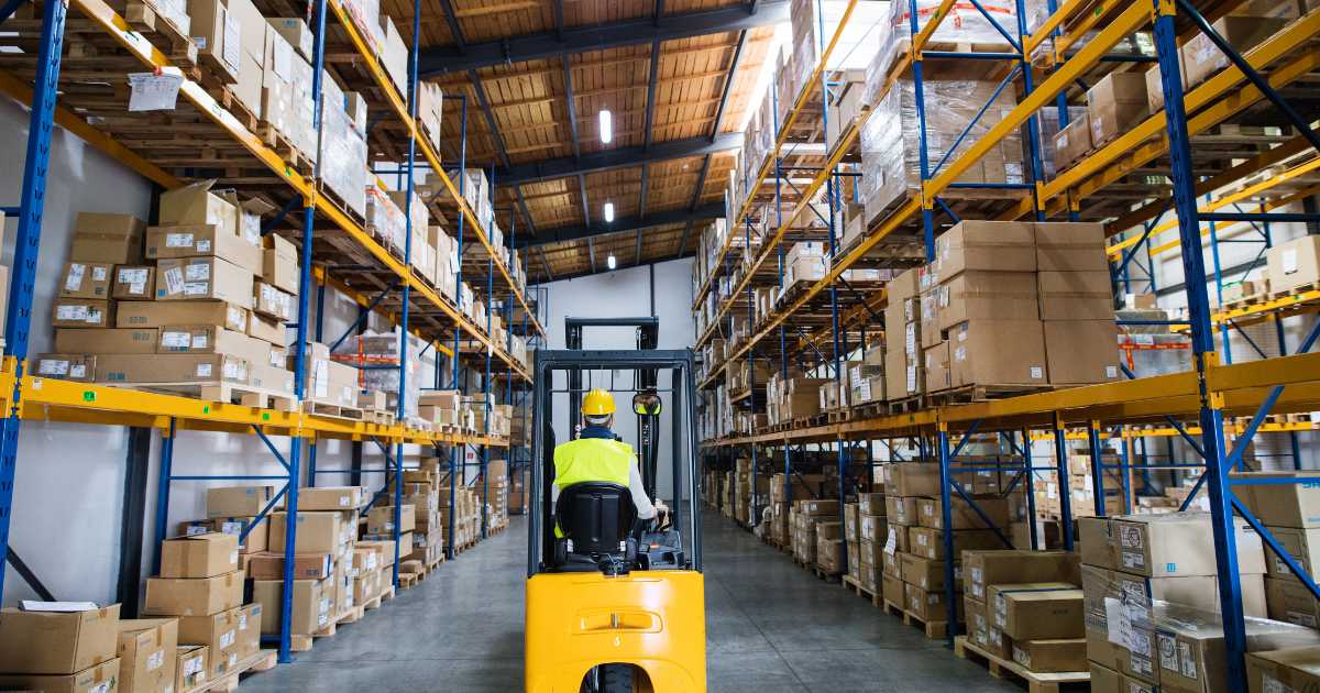 A worker driving a forklift in a warehouse.
