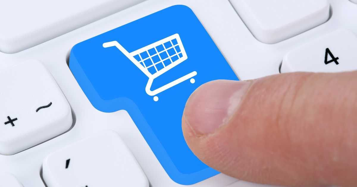 A person hitting a computer button with a shopping cart icon on it.