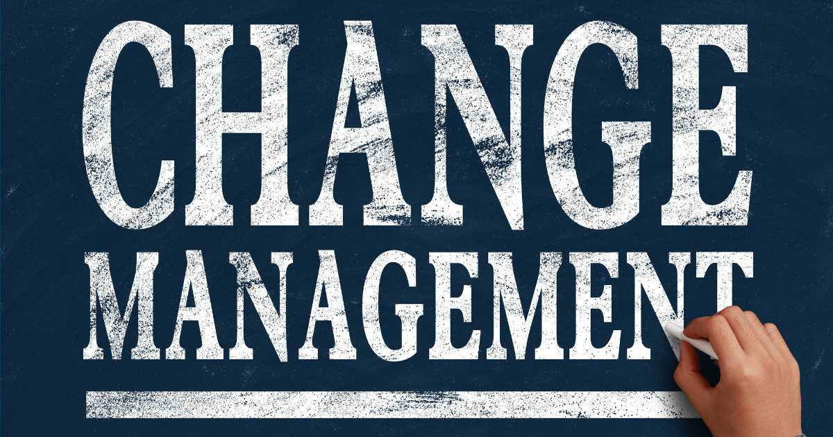 A person writing "Change Management" on a chalk board