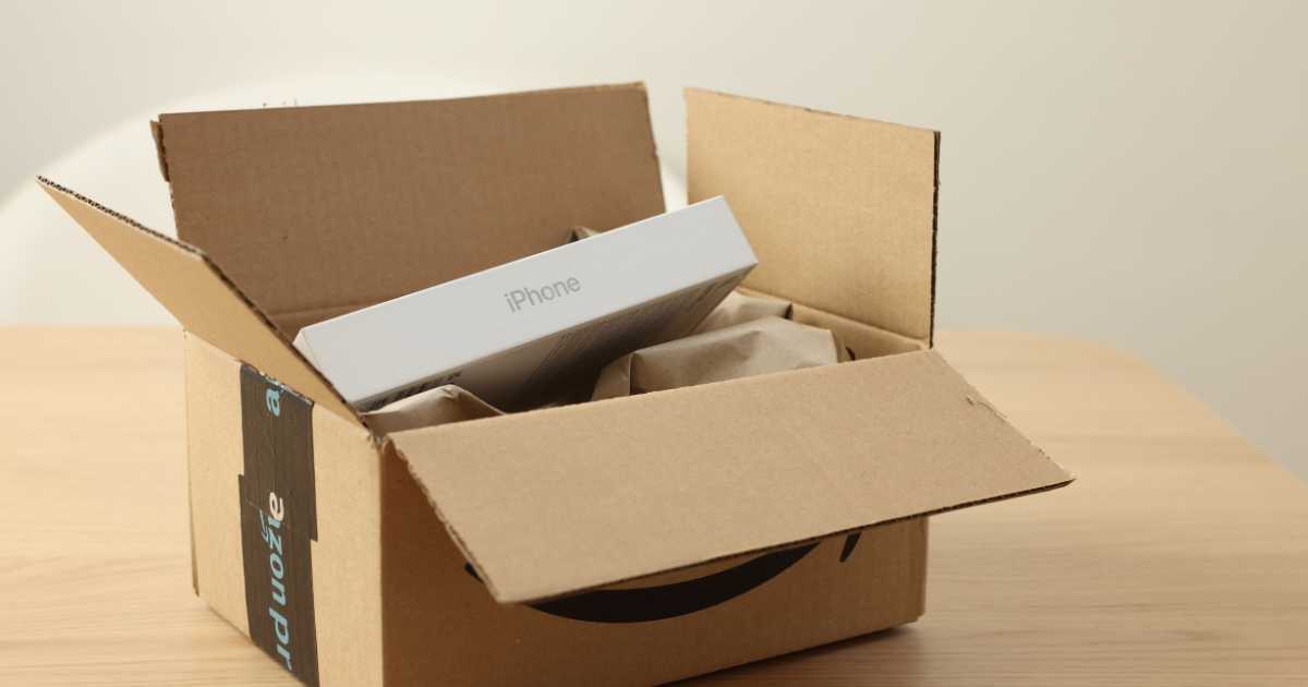 An open Amazon shipping box with an iPhone box inside it.