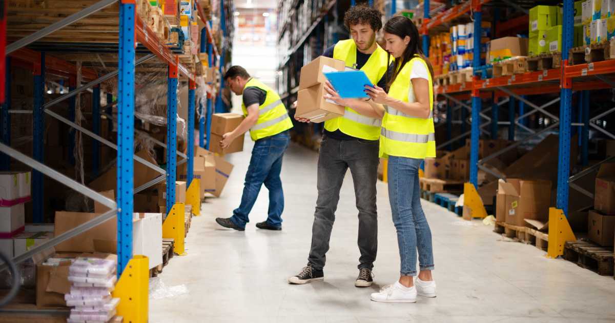 Picture of warehouse workers reviewing order fulfillment forms.