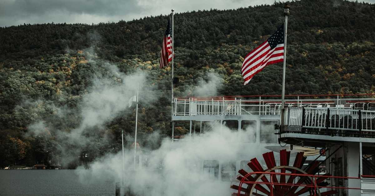 Image of a steamboat with two American flags on it. 