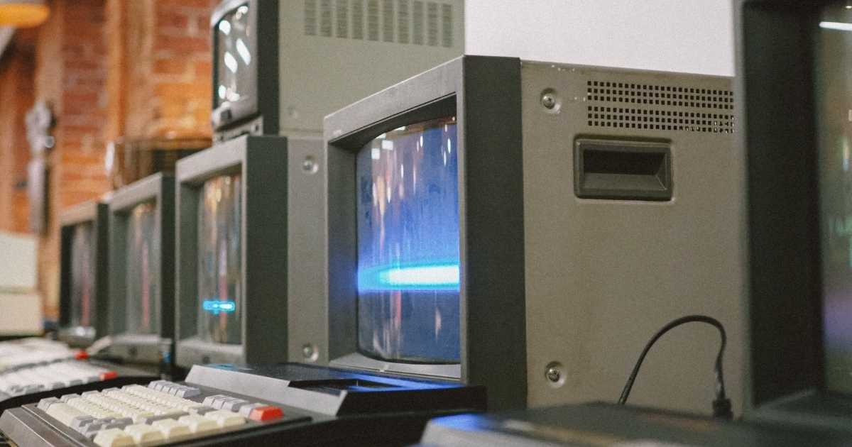 A picture of 1980s computers on desks. 