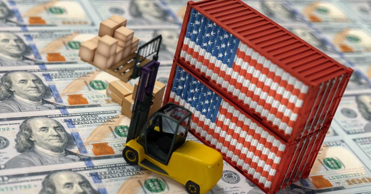 An image of 100 dollar bill sheets from a printing press with a small yellow forklift and 2 shipping containers with American flags on the side of them.