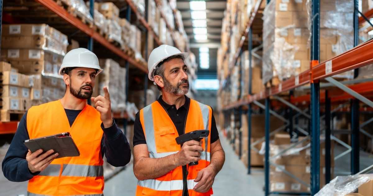 Two warehouse workers taking inventory.