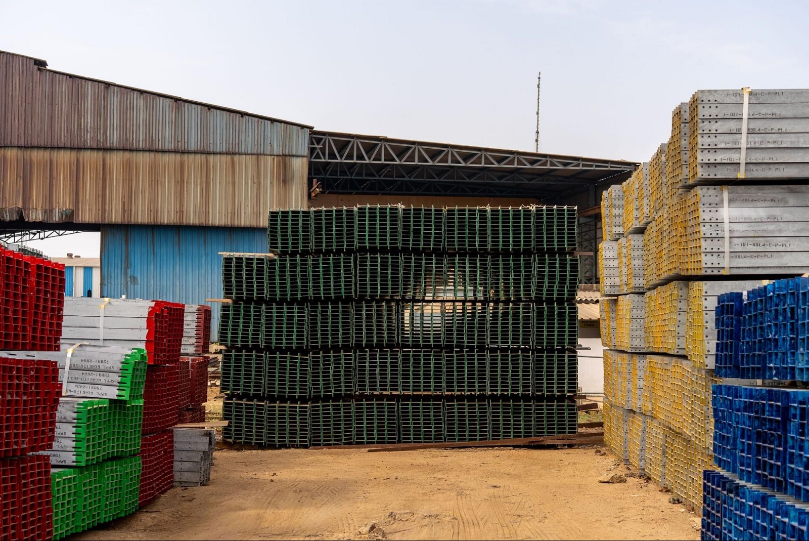 Stacks of colored steel construction materials organized in an outdoor yard