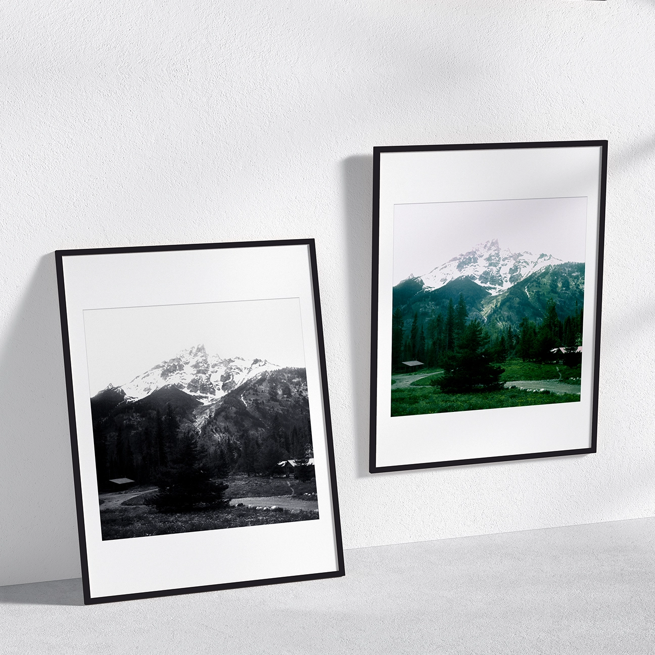 Short: Two framed prints of Grand Teton Peak and Village—one black-and-white, one color—on a white wall.