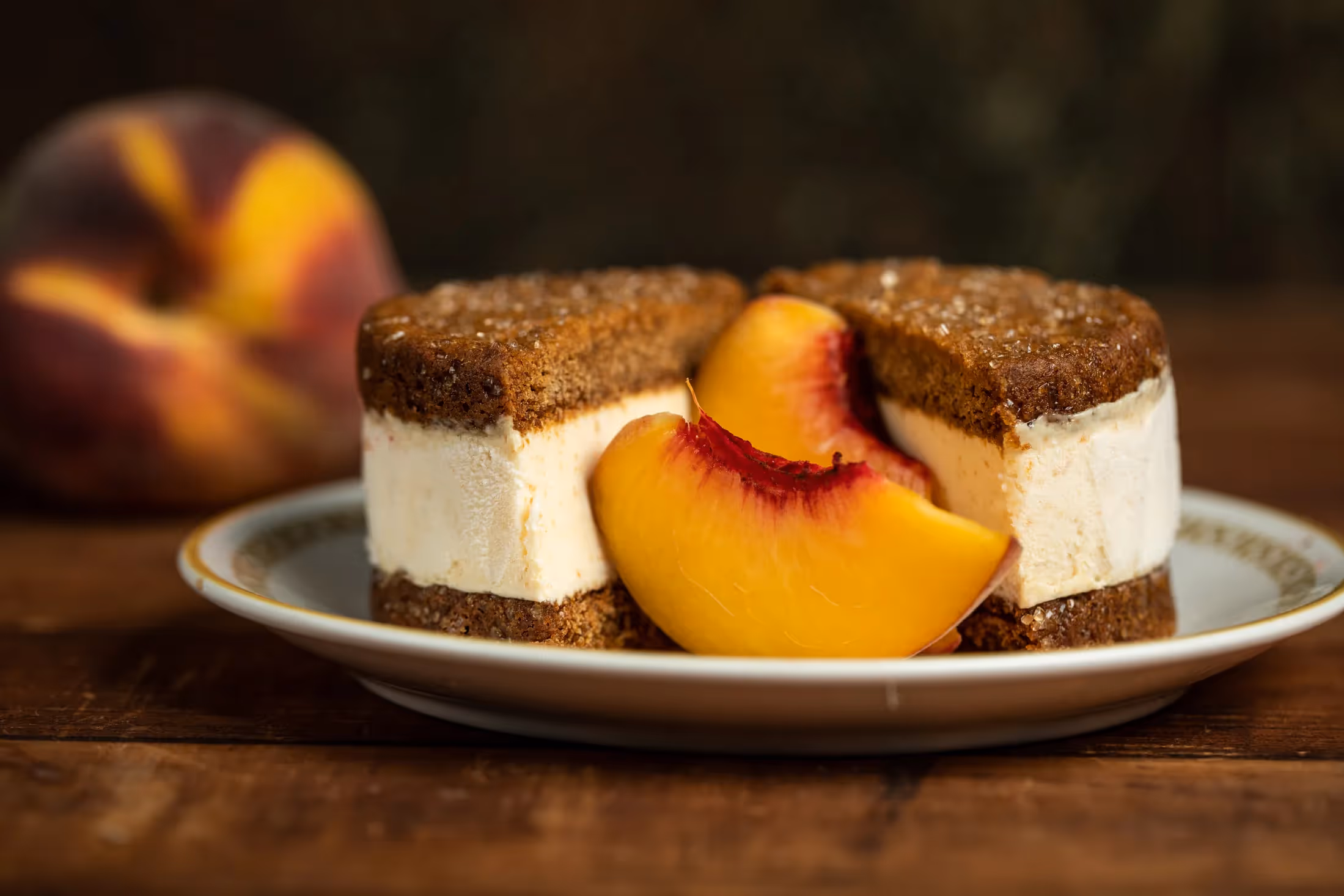 Leona's Ice Cream Sandwich split in half on a plate with peaches
