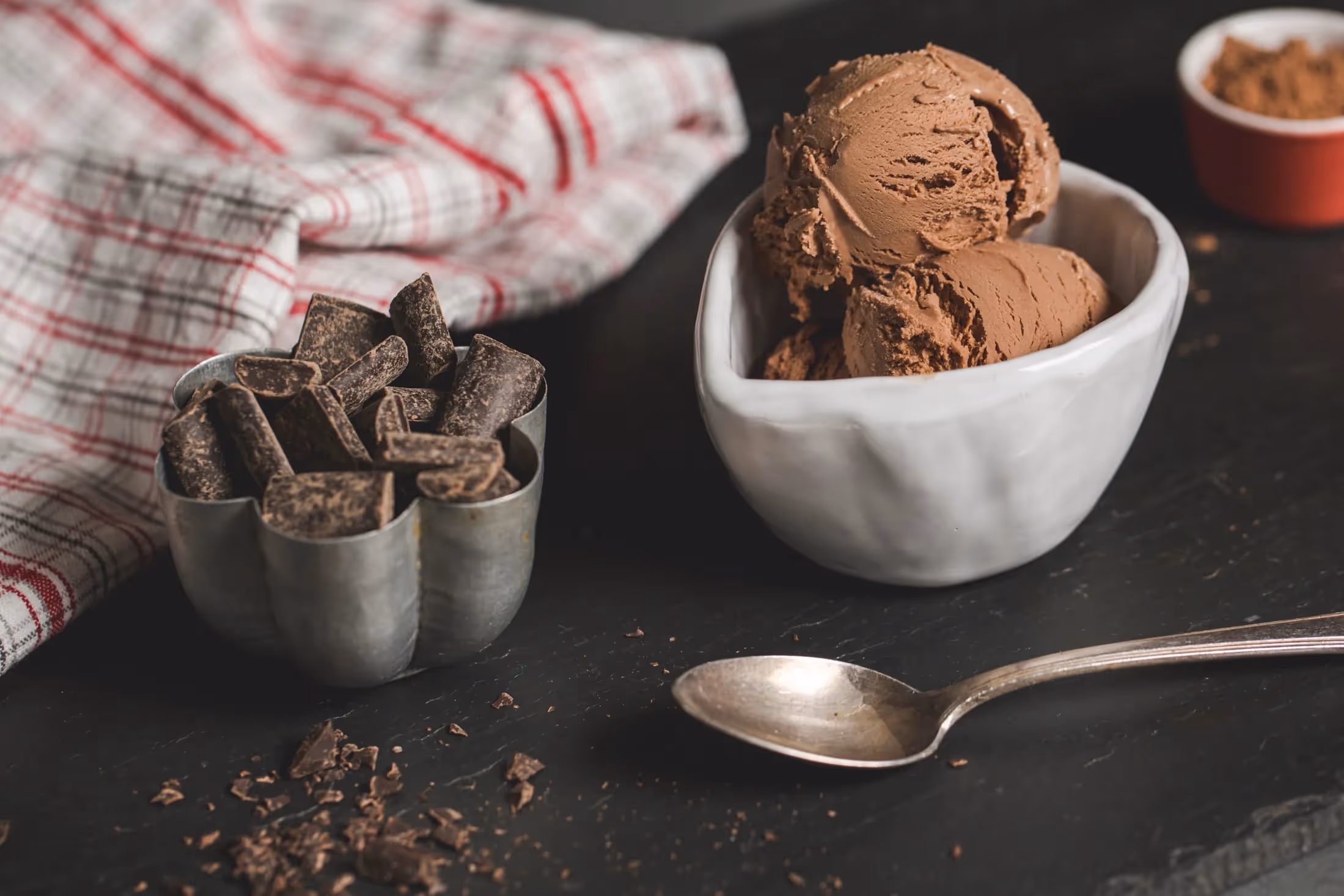 Bowl of Leona's ice cream next to a bowl of chocolate shavings