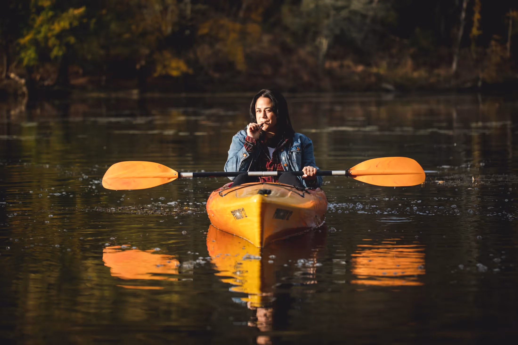 Maitri patient in a kayak on a lake in the fall forest