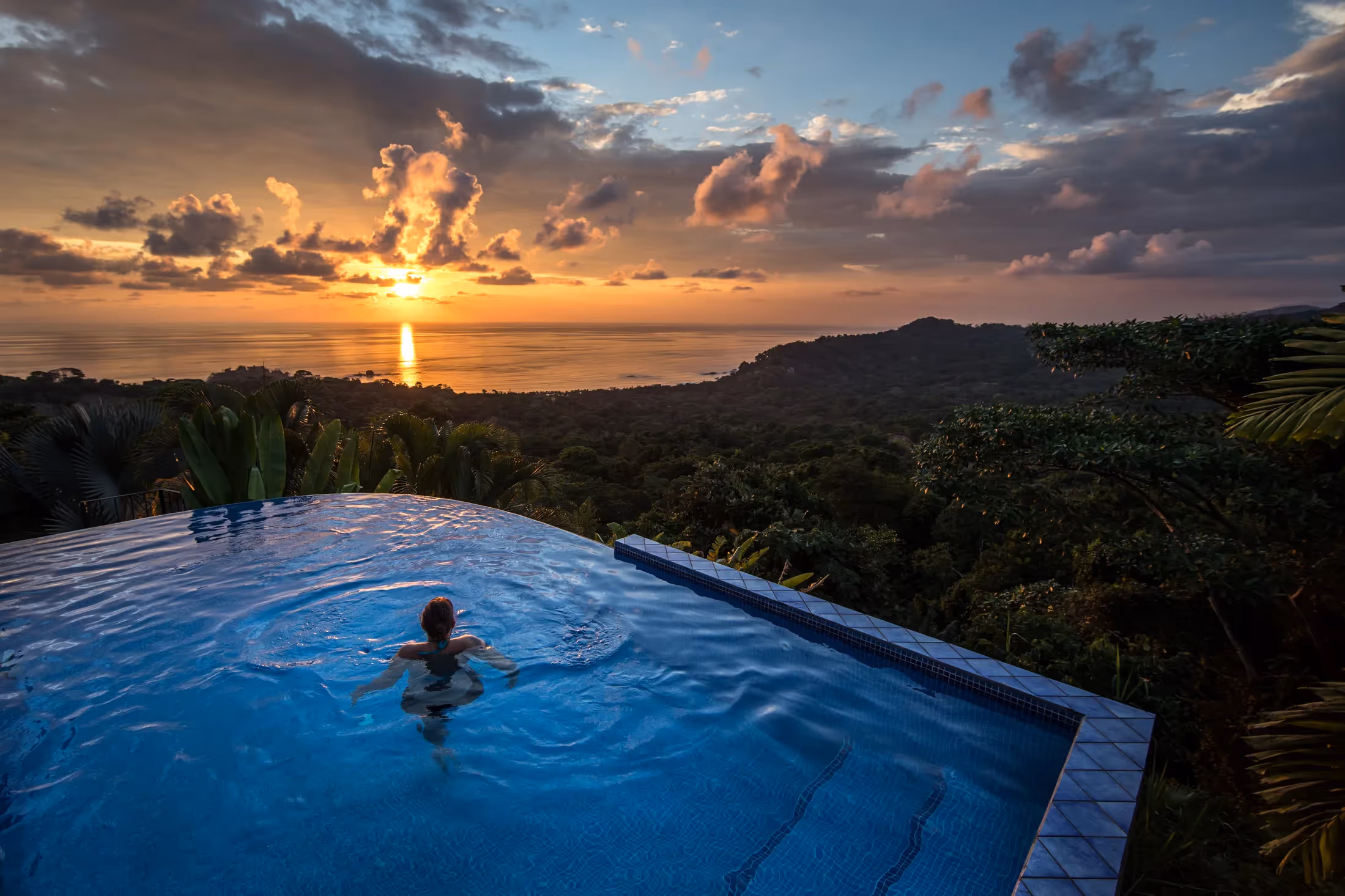 Person in swimming pool at sunset