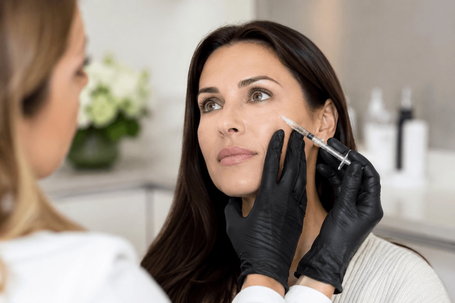 Patient receiving dermal filler treatment to restore under-eye and cheek volume for a refreshed, natural look in Buckhead Atlanta Georgia