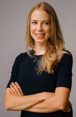 A woman with her arms crossed posing for a picture.