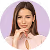 A woman in a pink shirt is holding her hands together.