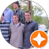Group of friends posing outdoors, smiling for the camera, with trees in the background.