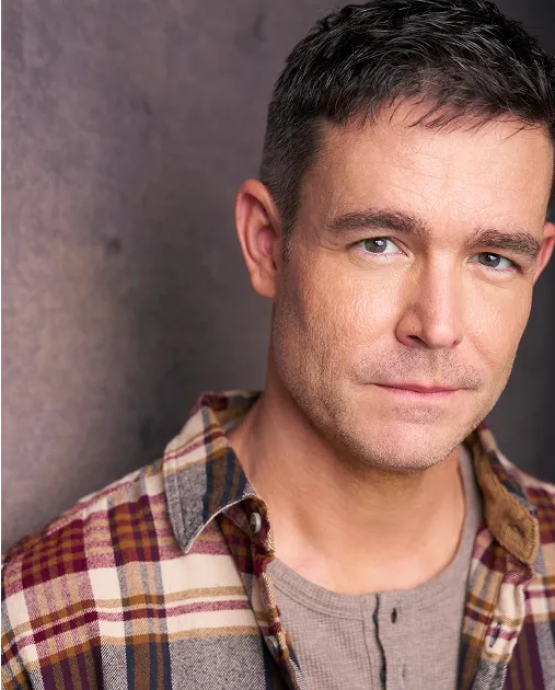 Atlanta theatrical actor headshot — male actor in plaid shirt with subtle serious expression, grounded and dramatic look against studio background