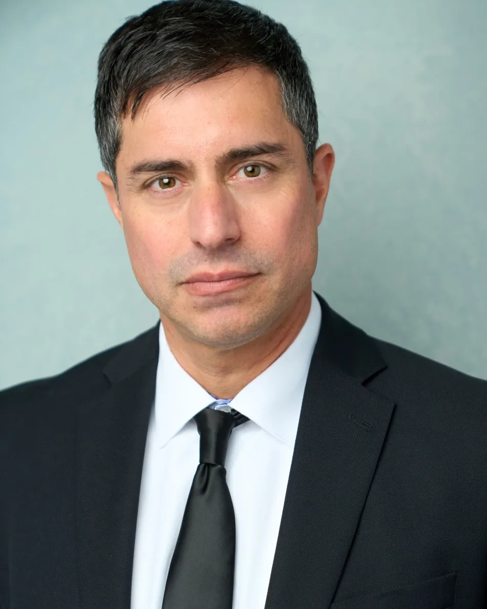 Atlanta theatrical actor headshot — male actor in suit and tie with serious professional expression, neutral background, authority role type.